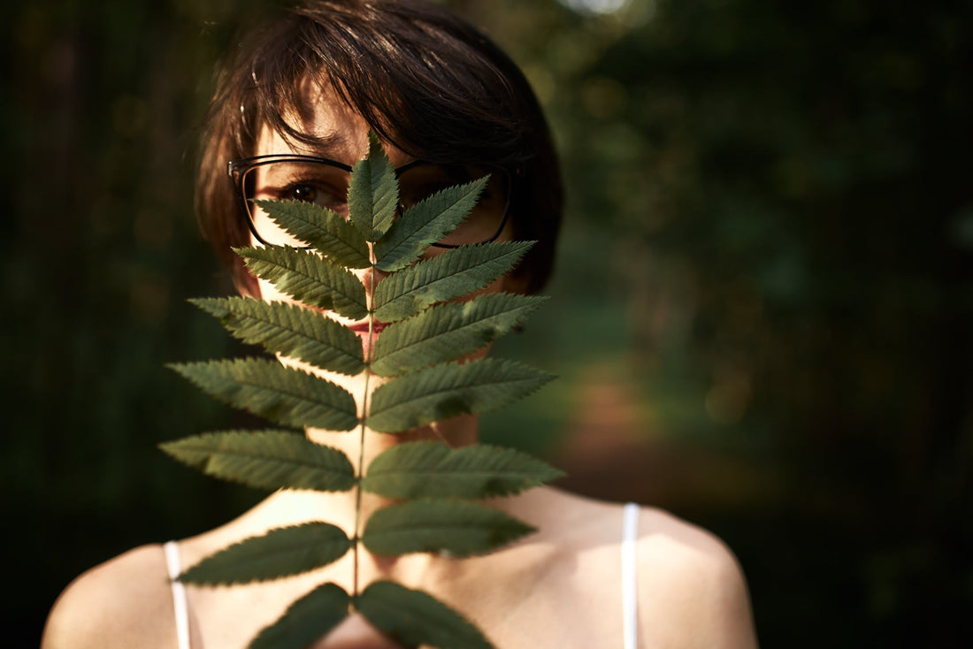 A women curiously looking through leaves