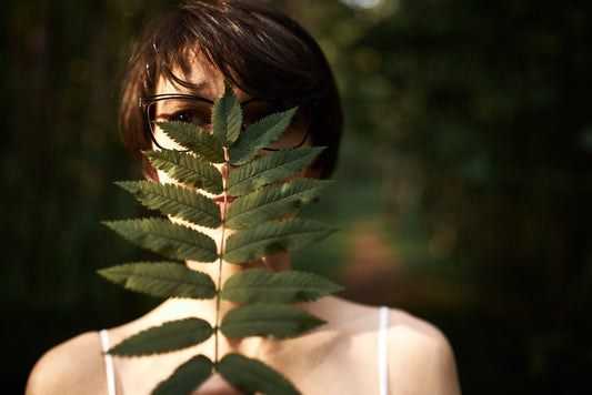 A women curiously looking through leaves