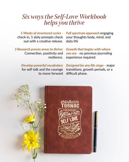 Brown leather notebook with 'Self Love' design and pen on a light background